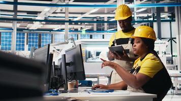 Black employees analyzing production line solar panels in the photovoltaics factory, analyzing data. Manufacturing plant engineers reading documentation files to troubleshoot errors. Camera B. video
