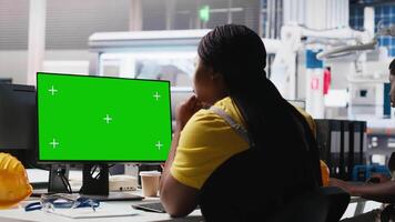 Black technician in photovoltaics factory reviews system on mockup pc, inspecting program to identify errors. Photovoltaic plant worker adjusting manufacturing parameters on monitor. Camera A. video