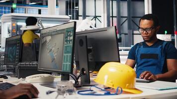 Black engineer runs diagnostic checks on solar panel assembly software, optimizing the production process and solar cells designs for alternative energy. High tech modern factory. Camera B. video