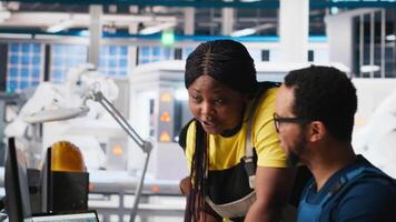 African american colleagues analyze power data from solar production line, teamwork gathered around desktop computer. Engineers optimizing configurations for sustainable energy. Camera A. video