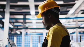 Engineer using laptop to monitor solar panel plant assembly lines, troubleshooting photovoltaic equipment to ensure seamless production workflow. Automation for alternative energy. Camera A. video