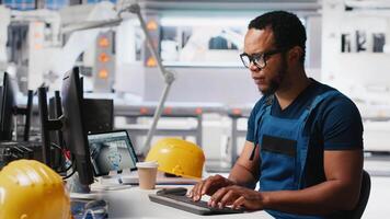 Black engineer implements automation logic in solar factory software, working on manufacturing solar panel designs for alternative energy. High tech production line. Camera A. video