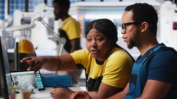 Employees work on photovoltaic design updates in clean energy plant, reducing downtime for operational efficiency in a solar panel factory. Black team of engineers fixing technical issues. Camera A. video