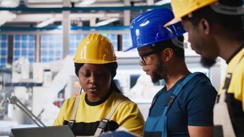 Engineering group in solar panel factory adjusting machinery settings through tablet, inspecting the production and configuration for efficient production. Teamworking. Camera A. video