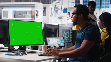 African american male engineer does troubleshooting on copy space display, fixing errors to ensure seamless solar panels manufacturing. Technician works in the assembly line Camera A video