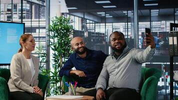 Multiethnic business people seal their partnership with a picture on social media, reaching a verbal agreement for a new international collaboration. CEOs taking photos on media platforms. Camera B. video
