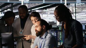 Admins doing brainstorming in server hub, reviewing machine learning code and LLM visualization dashboards. Data center IT experts using computer to monitor AI infrastructure performance, camera A video