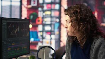 Filmmaker working on media post production from agency office, ensuring the editing timeline and color correction for a shoot. Tech driven workspace showcases a digital workflow. Camera B. video