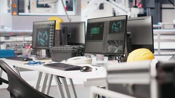 Monitors in photovoltaics factory used to manage performance of robot arms placing solar panels on assembly lines. PC screen in empty facility used for upgrading solar cell machinery. video