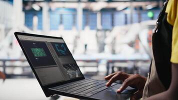 Solar panels male worker analyzing performance data on laptop and optimizing efficiency. Photovoltaics factory engineer working on innovative solar cells design prototype, high tech. Camera B. video