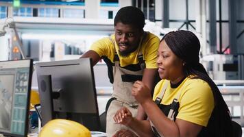 Black engineering team working at a high tech solar panel factory, reducing downtime and finetuning to a seamless production process. Technicians optimizing solar energy manufacturing. Camera A. video