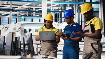 Solar panels engineers team developing new photovoltaic materials using devices in the manufacturing plant. Black workers group conducting experiments for better production line. Camera B. video