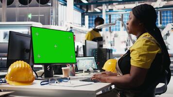 Black technician in photovoltaics factory reviews system on mockup pc, inspecting program to identify errors. Photovoltaic plant worker adjusting manufacturing parameters on monitor. Camera B. video