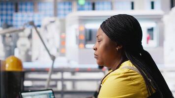 African American worker programs automation settings in solar facility, focused on efficiency and sustainability. Female engineer manages configurations for improved power output. Camera A. video