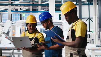 Group of black employees at the solar panels factory reviewing data on devices and documents. Photovoltaics facility engineers working on innovative solar cells design prototype. Camera A. video