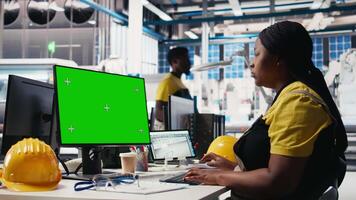 Black woman working in photovoltaics factory using copy space on PC to improve solar panels assembly processes. Assembly line engineer using mockup computer to calibrate equipment. Camera B. video