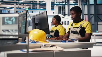 Black engineer develops power optimization models in solar panel production, working on PC software to increase renewable energy photovoltaic systems. Eco friendly industry. Camera B. video