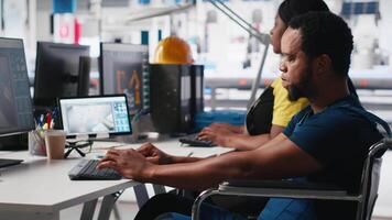 Black factory employee with chronic disability designs solar panels on pc, creating cheaper solar cells for alternative energy. Engineer in inclusive workspace testing photovoltaic system. Camera A. video
