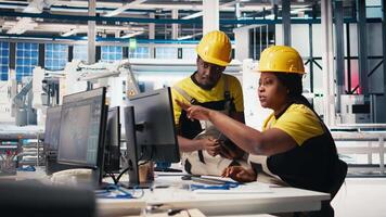 African american workers checking up on manufacturing equipment in solar panel factory, reading documentation files. Team of engineers in industrial facility inspecting production process. Camera B. video