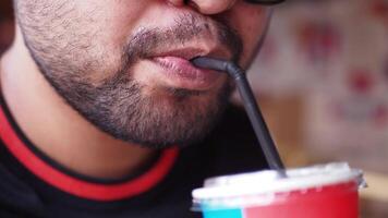 Man enjoys drink while seated in cafe during casual outing video