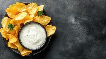 Dip chips in a bowl with a spoon on a black background photo