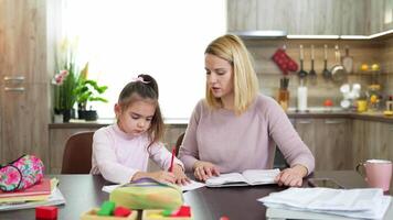 Engaging learning moments between mother and daughter in a cozy home setting while working on homework tasks together video