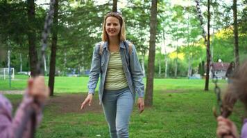 Swinging and laughter fill the park as a caregiver enjoys a sunny day with young children video