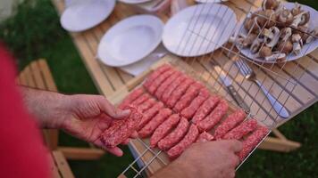 Grilling delicious skewers of marinated meat at a summer barbecue gathering in the backyard under golden sunsets video