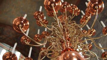 Ornate copper and gold chandelier in Orthodox church video