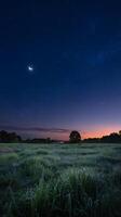 A night sky with a crescent moon and a field photo