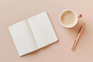 A notebook is open to a blank page with a pen and a cup of coffee on a table photo