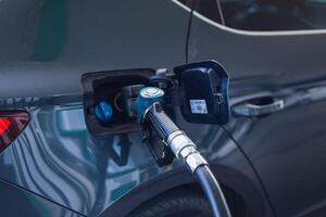 Fueling a dark sedan at a modern gas station during daylight hours photo