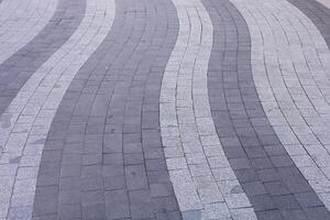 Unique wave patterns of paving stones create a striking urban walkway design. photo
