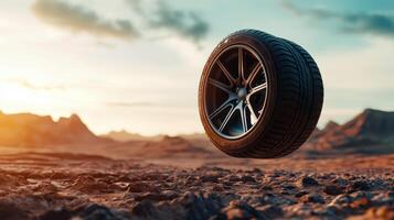 Futuristic car tire on desert terrain at sunset with dramatic sky highlighting shadows and reflections for an automotive adventure theme. Tires with rubber tread on alloy wheels photo