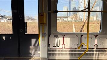 Urban train interior with sunlit windows and modern cityscape in background on a clear day highlighting urban transit and architecture photo