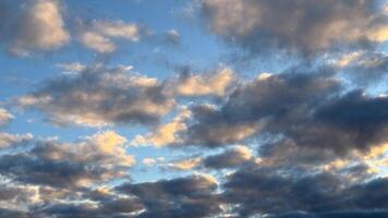 Luminous sunset clouds in a vibrant sky reflecting warmth and tranquility over a peaceful horizon of soft blue and dusky grey tones photo