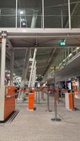 Modern airport departure area with orange check-in counters and glass ceiling in a spacious terminal during quiet nighttime hours photo