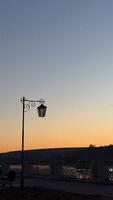 A serene dusk scene with an artistic vintage lamp post and a crescent moon against a peaceful sunset sky creating a tranquil atmosphere photo