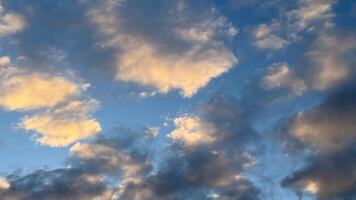 Stunning sky scene with fluffy clouds at sunset displaying a beautiful palette of orange and blue in a serene evening atmosphere photo