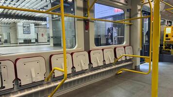 Modern subway interior with vibrant yellow bars and empty gray seats in a sleek urban train station focusing on clean lines and architecture photo