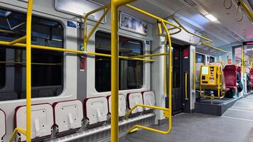 Modern city train with yellow handrails and seating arrangements for passengers in a spacious and well-lit interior creating a comfortable journey photo