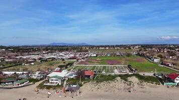 Coastal view on a sunny day showcasing vibrant greenery and distant mountains with a lively beach atmosphere video