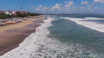 Coastal view with waves, umbrellas, and beachgoers in Lombok video