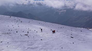 Hikers on a snowy mountain path with panoramic views of the Caucasus video