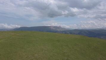 Large, grassy hill with a cloudy sky in the background video