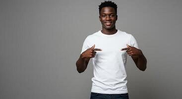 A young man in a white t - shirt pointing at the camera photo