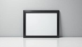 Empty black picture frame on a white surface against a light gray wall. photo
