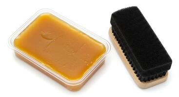 A brush and a container of yellow wax photo