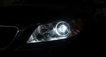 A close up of a car's headlights in the dark photo