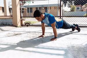 Athletic Hispanic man holding up with hands doing push-ups. healthy concept photo